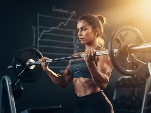 Persoon tilt een barbell in een moderne sportschool, spieren gespannen, krijtgrafiek op donkere muur, warm gouden licht.
